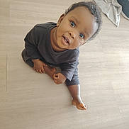 Djawël participe au concours pour gagner de l'argent avec cette photo : baby, barefoot, blanket, child, clothing, curious, eyes, face, hair, hand, indoor, looking_up, onesie, playful, portrait, sitting, smile, toddler, towel, wooden_floor