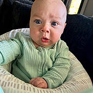 Crew Jensen joined the competition — help win amazing prizes! baby, infant, child, onesie, green_clothing, cushion, face, blue_eyes, indoor, window, furniture, living_room, expression, curious, portrait, sitting, closeup, person, home, soft_lighting