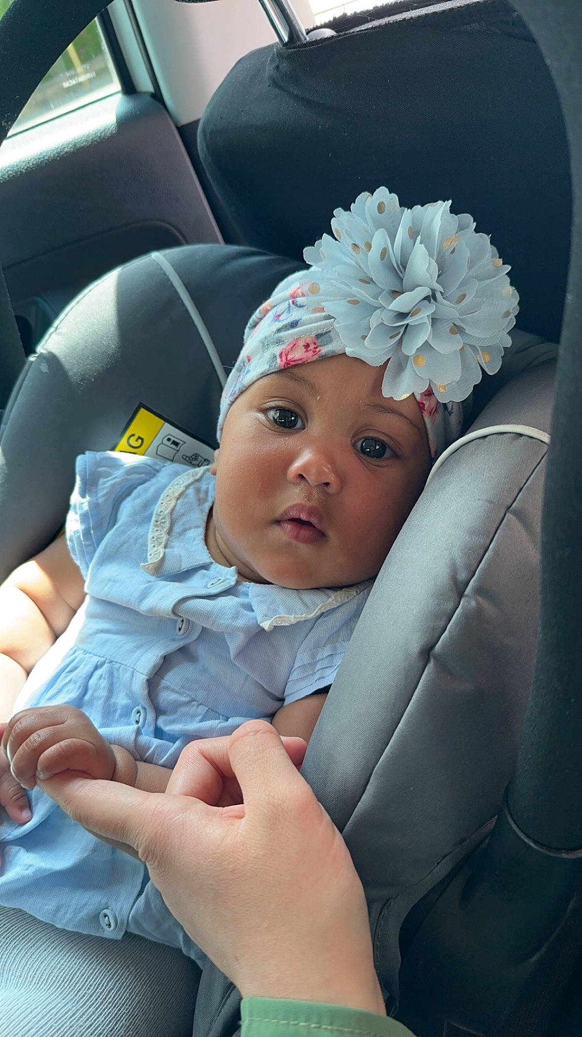 Coumba participe au concours pour gagner de l'argent avec cette photo : baby, baby_products, baby_toddler_clothing, cap, car_seat, child, comfort, face, finger, flower, gesture, hairstyle, hand, headwear, nail, person, product, sitting, skin, thumb