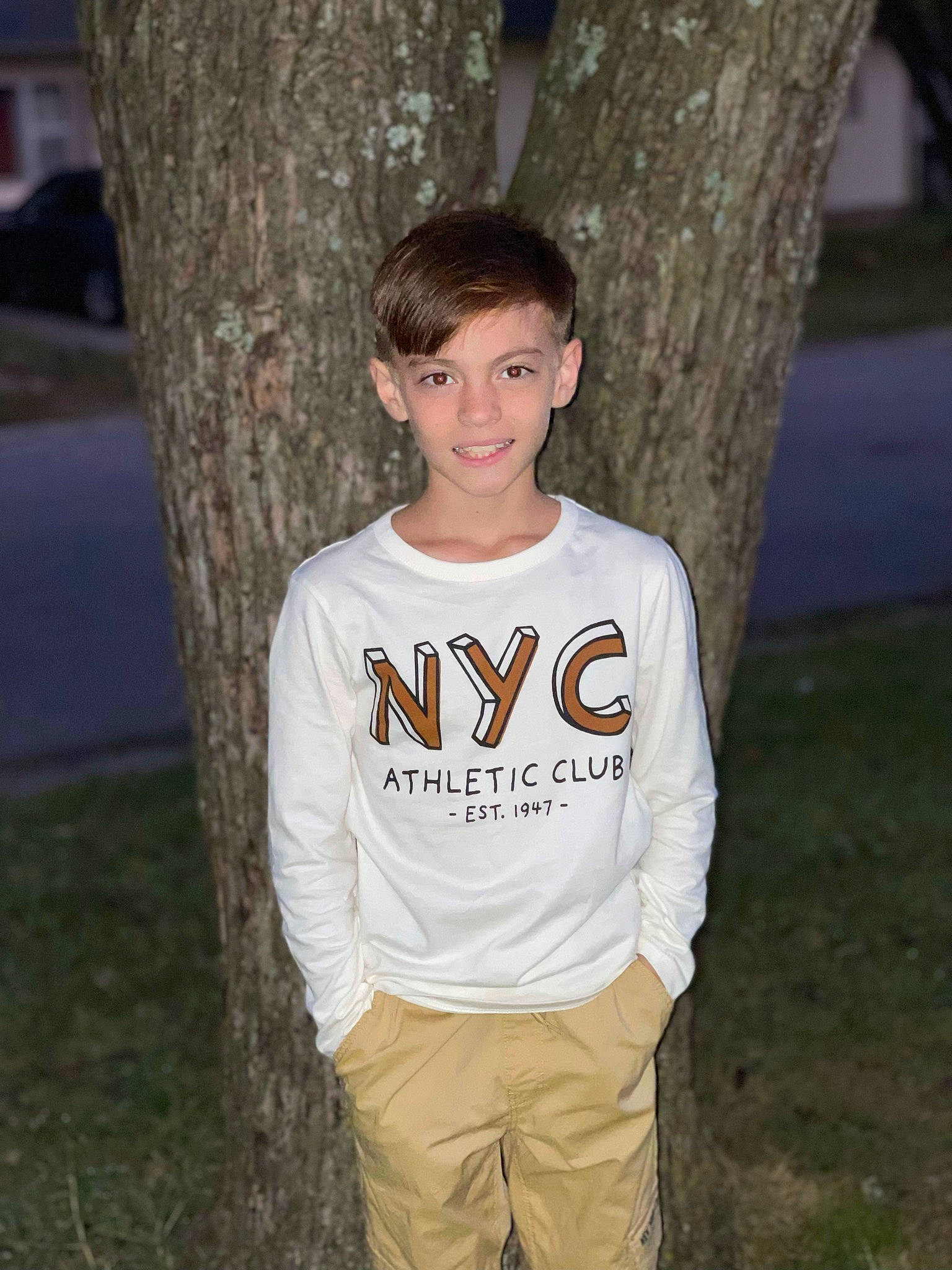 Karsin is registered to the contest to win money with this photo: chest, clothing, flash_photography, fun, grass, grey, happy, jaw, joy, leisure, person, plant, sitting, sleeve, smile, t_shirt, tree, trunk, waist, wood