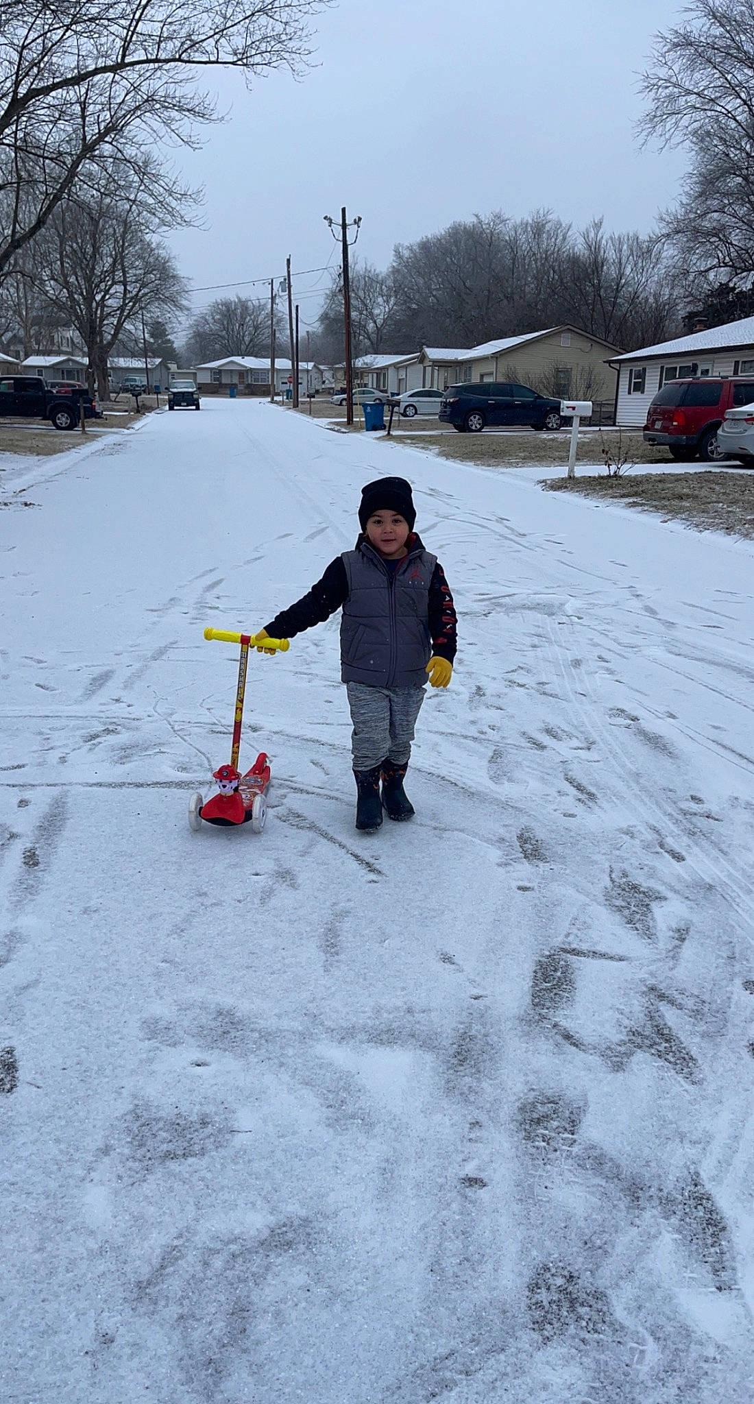 Linkin is registered to the contest to win money with this photo: asphalt, automotive_tire, car, driveway, freezing, fun, geological_phenomenon, grass, headwear, motor_vehicle, person, recreation, road_surface, sidewalk, sky, slope, snow, tire, tree, vehicle