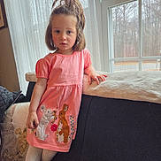 Willow joined the competition — help win amazing prizes! child, girl, pink_dress, rabbit_design, window, curtains, couch, pillow, indoors, natural_light, long_hair, white_tights, brown_boots, leaning, portrait, home, furniture, expression, casual, daylight