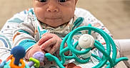 Rayan is registered to the contest to win money with this photo: baby, infant, child, face, eyes, smile, hands, toy, baby_seat, colorful, indoor, playful, clothing, cute, expression, focus, portrait, young, soft_background, sitting