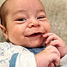 Rayan is registered to the contest to win money with this photo: baby, smiling, closeup, face, hands, infant, cute, portrait, child, cozy, clothing, expression, playful, skin, young, person, indoor, soft_light, happy, newborn