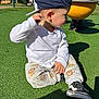 Jude participe au concours pour gagner de l'argent avec cette photo : toddler, child, cap, white_shirt, animal_print_pants, black_shoes, playground, artificial_grass, outdoor, sunny, daylight, fence, toy, sitting, looking_sideways, shadow, casual_clothing, young_child, cute, park