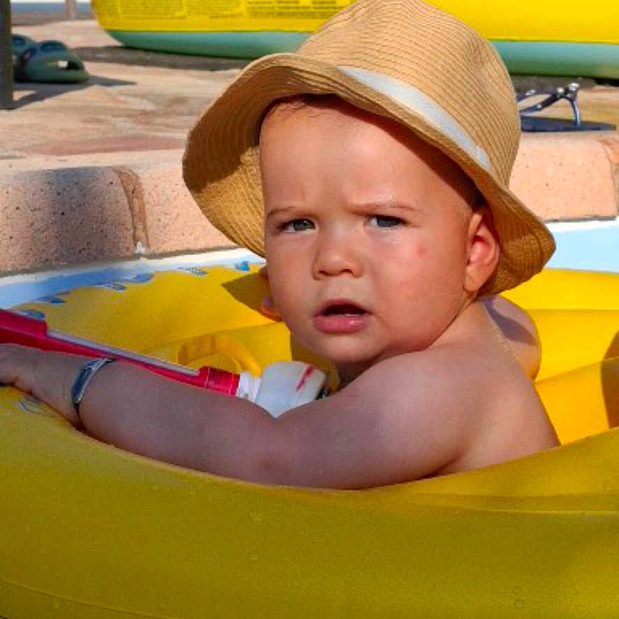 Paul-André a rejoint le concours — aidez-le/la à gagner de superbes lots ! arm, baby, child, daylight, expression, face, float, hat, inflatable_pool, outdoor, pool, recreation, skin, summer, sunlight, swimming, toddler, toy, water, yellow