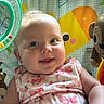 Blakley is registered to the contest to win money with this photo: baby, child, infant, smiling, portrait, close_up, sitting, bouncer, baby_seat, plush_toy, toy, floral_clothing, pink, colorful, indoor, sunlight, houseplant, window, happy, photography
