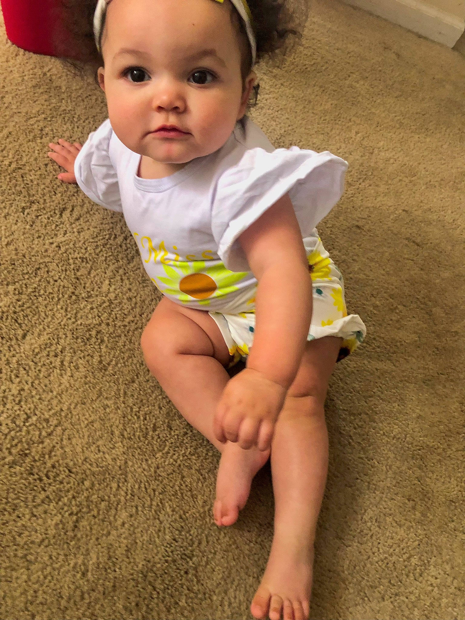 Lilly is registered to the contest to win money with this photo: baby, baby_toddler_clothing, barefoot, cheek, child, elbow, eye, face, flooring, foot, happy, head, human_body, human_leg, iris, knee, person, skin, sleeve, thigh