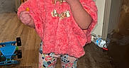 Nataly is registered to the contest to win money with this photo: baby, boots, bow, child, finger_in_mouth, fluffy_coat, headband, home, indoor, laundry, patterned_leggings, pink_outfit, portrait, refrigerator, smiling, standing, toddler, toys, water_bottle, wooden_floor