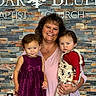 Nataly is registered to the contest to win money with this photo: child, toddler, baby, mother, family, portrait, smiling, indoors, church, stone_wall, brick, religious_building, dresses, red_shirt, overalls, holding_baby, standing, family_photo, people, photography