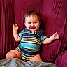 baby, child, smiling, sitting, portrait, indoor, couch, purple_couch, blanket, striped_outfit, onesie, happy, face, arms_raised, brown_hair, furniture, cozy, home, photography, infant