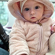Sofia is registered to the contest to win money with this photo: baby, child, hoodie, fur, cute, portrait, face, big_eyes, hand, soft_texture, warm_clothing, indoor, person, closeup, adorable, infant, pink, cozy, looking_at_camera, young