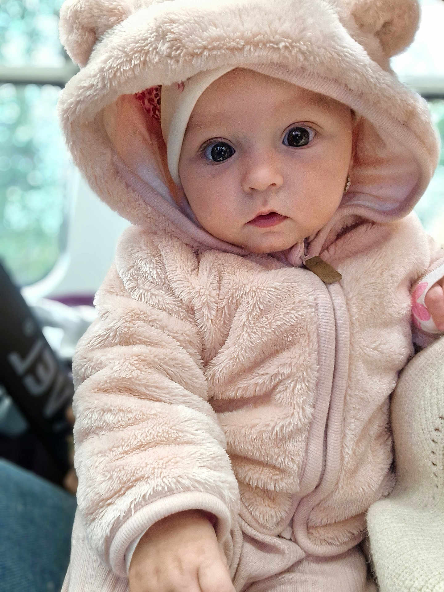 Sofia is registered to the contest to win money with this photo: baby, child, hoodie, fur, cute, portrait, face, big_eyes, hand, soft_texture, warm_clothing, indoor, person, closeup, adorable, infant, pink, cozy, looking_at_camera, young