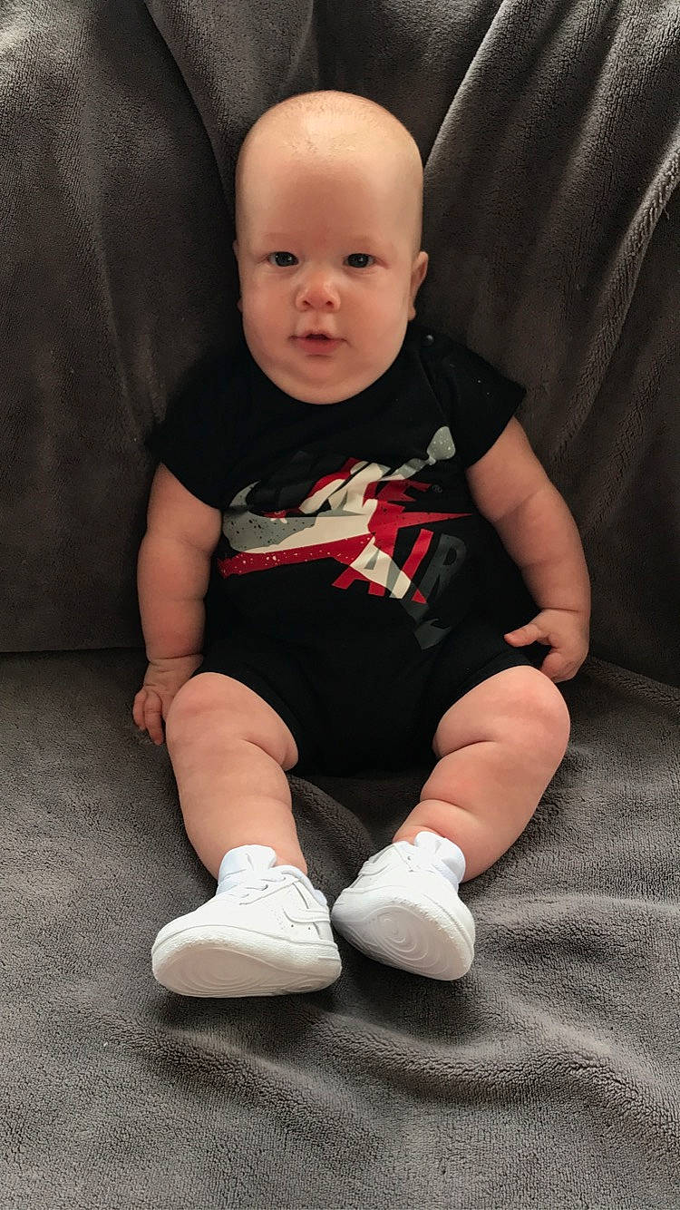 Zadryan is registered to the contest to win money with this photo: baby, baby_toddler_clothing, cheek, child, chin, comfort, eye, face, finger, floor, flooring, head, human_leg, knee, lap, person, skin, sleeve, sock, t_shirt