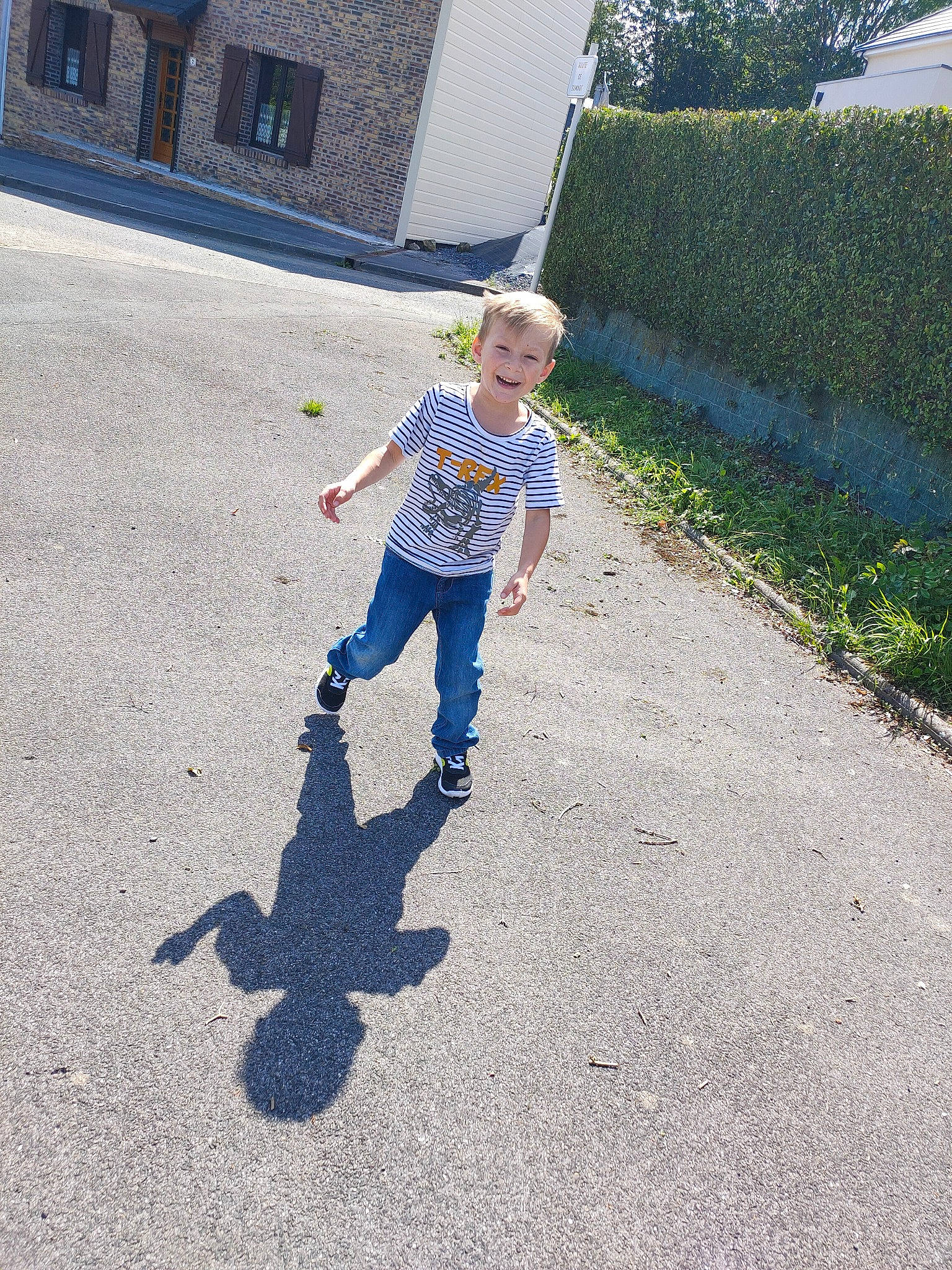 Gabin participe au concours pour gagner de l'argent avec cette photo : asphalt, child, cottage, denim, driveway, hedge, jeans, joy, person, play, shadow, shrub, sweatpant, tar, toddler, walking, walking_shoe, yard