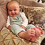 Ralph is registered to the contest to win money with this photo: baby, smiling, couch, pillow, infant, clothing, feet, toes, face, happy, indoors, person, sitting, dinosaur, cozy, blanket, home, cute, child, portrait