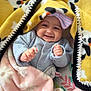 baby, smiling, blanket, yellow_blanket, pink_blanket, bow, headwear, infant, cute, happy, cozy, panda_pattern, clothing, indoor, portrait, child, soft_texture, wrapped, hands, lying_down