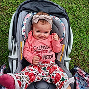 Wrennley is registered to the contest to win money with this photo: baby, child, car_seat, grass, pink_clothing, headband, socks, pumpkin_pattern, outdoor, smiling, cute, infant, seat_belt, floral_pattern, happy, person, toddler, fall_theme, baby_girl, casual