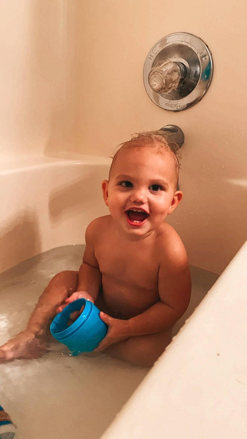 Chase is registered to the contest to win money with this photo: baby, baby_bathing, bathing, bathroom, bathtub, chest, child, fun, happy, joy, leisure, mechanical_fan, organ, person, personal_care, plumbing, plumbing_fixture, room, skin, smile
