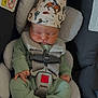 newborn, baby, car_seat, hat, sleeping, knitwear, green_clothing, safety_harness, infant, child, cute, peaceful, indoor, resting, soft_padding, baby_clothes, car_safety, baby_hat, cozy, child_seat