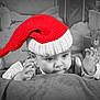 baby, santa_hat, blanket, teddy_bear, christmas, holiday, presents, festive, child, cute, black_and_white, red, knit_hat, smiling, portrait, indoors, soft_texture, decorations, holiday_season, young_child