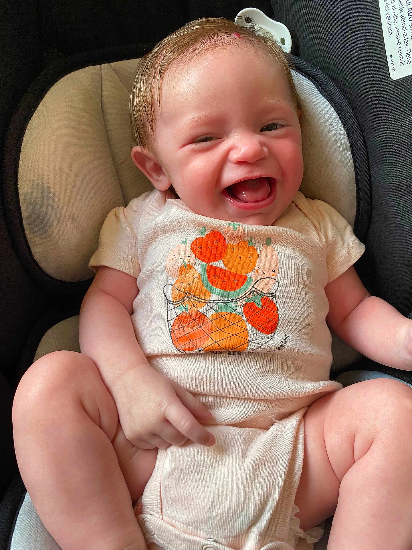 Sophia joined the competition — help win amazing prizes! baby, smiling, onesie, fruit_illustration, cushioned_seat, happy, infant, cute, child, clothing, skin, hand, legs, face, joy, comfort, indoor, young, sitting, expression