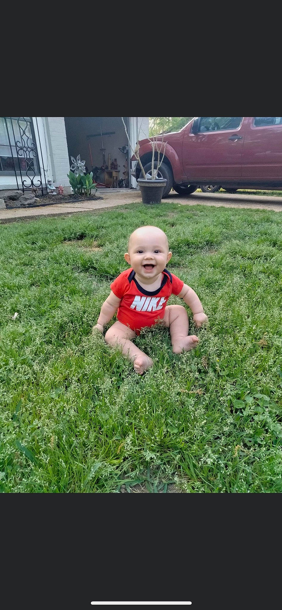Jaxson is registered to the contest to win money with this photo: automotive_design, automotive_exterior, automotive_lighting, automotive_tire, baby, flooring, grass, groundcover, happy, joy, landscape, lawn, motor_vehicle, people_in_nature, person, plant, smile, t_shirt, tire, toddler