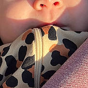 Arielle joined the competition — help win amazing prizes! baby, face, eyes, close_up, infant, skin, clothing, zipper, pattern, light, shadow, cute, child, portrait, young, warm_light, fabric, texture, soft, expression