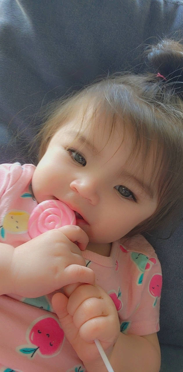 Yosselin is registered to the contest to win money with this photo: baby, baby_toddler_clothing, cheek, child, close_up, eyelash, facial_expression, finger, gesture, grass, hair, hand, happy, lip, mouth, nose, person, pink, skin, thumb