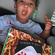 Aeries joined the competition — help win amazing prizes! child, snack, pretzels, food, bag, curly_hair, mouth_open, hand, indoor, person, casual_clothing, couch, relaxed, funny_expression, brown_skin, earrings, window_blinds, bottle, sitting, home