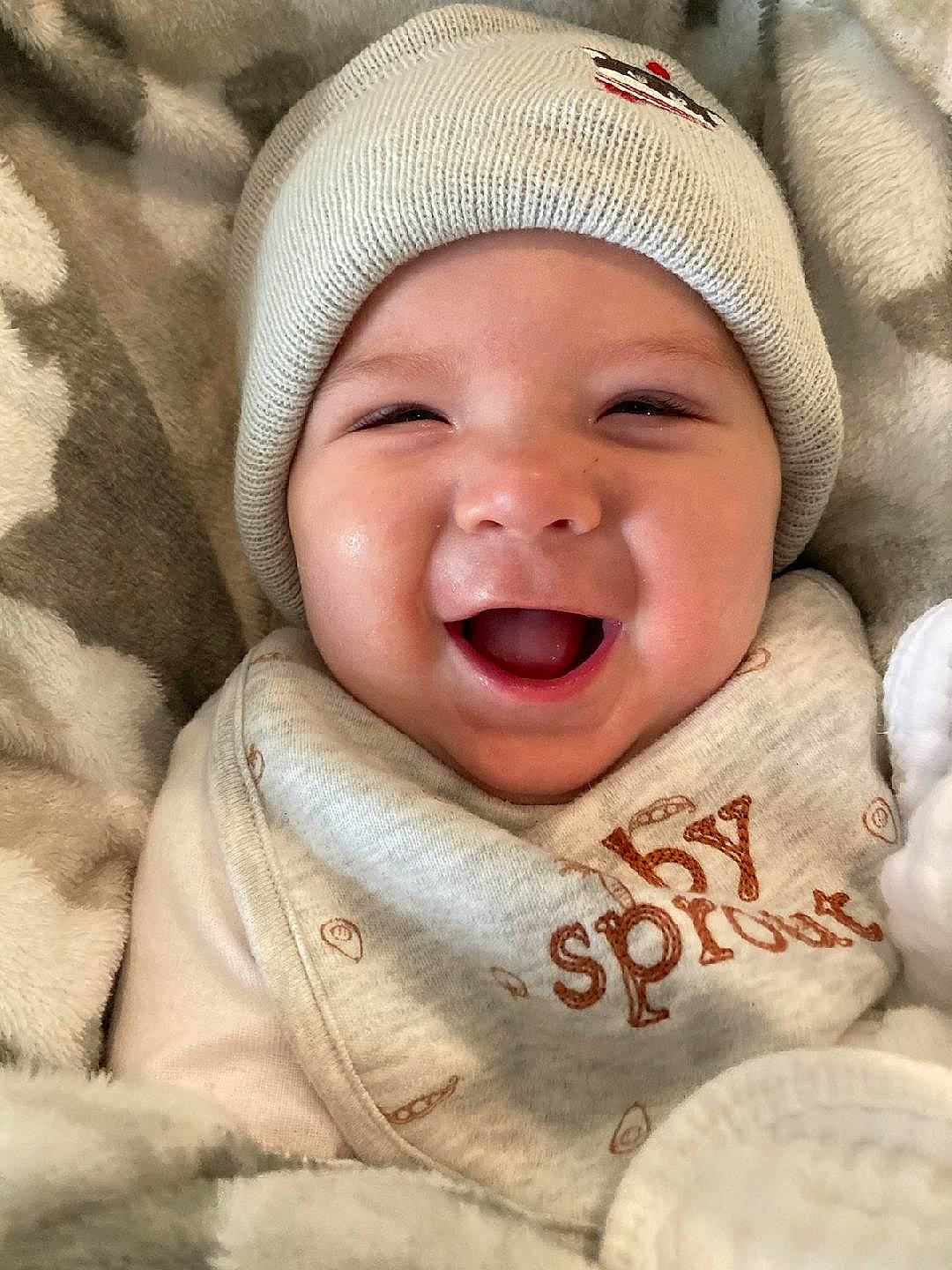 William is registered to the contest to win money with this photo: baby, baby_laughing, baby_toddler_clothing, cap, cheek, child, chin, comfort, fun, happy, headwear, linens, lip, mammal, mouth, nose, person, skin, sleeve, smile