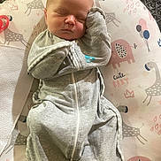 Raylyn is registered to the contest to win money with this photo: baby, newborn, sleeping, swaddle, gray_clothing, cushion, animal_pattern, elephant, giraffe, pink, blue, cute, indoor, peaceful, infant, face, head, soft_texture, resting, child