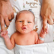 Raylyn is registered to the contest to win money with this photo: newborn, baby, infant, hand_holding, adult_hands, hospital_wristband, blanket, cartoon_characters, bed, cute, family, parental_love, skin, portrait, closeup, expression, lying_down, baby_face, newborn_baby, tender_moment