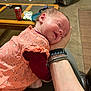 baby, infant, sleeping, peaceful, hand, peach_dress, maroon_sleeves, living_room, coffee_table, can, car_seat, blanket, carpet, person, sleep, face, head, soft_lighting, child, indoor