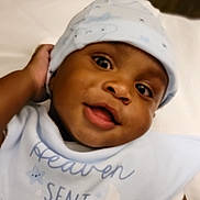Kyree is registered to the contest to win money with this photo: baby, child, smiling, face, hat, clothing, bib, blue, cute, portrait, infant, young_child, happy, indoors, headwear, closeup, expression, person, skin, eyes