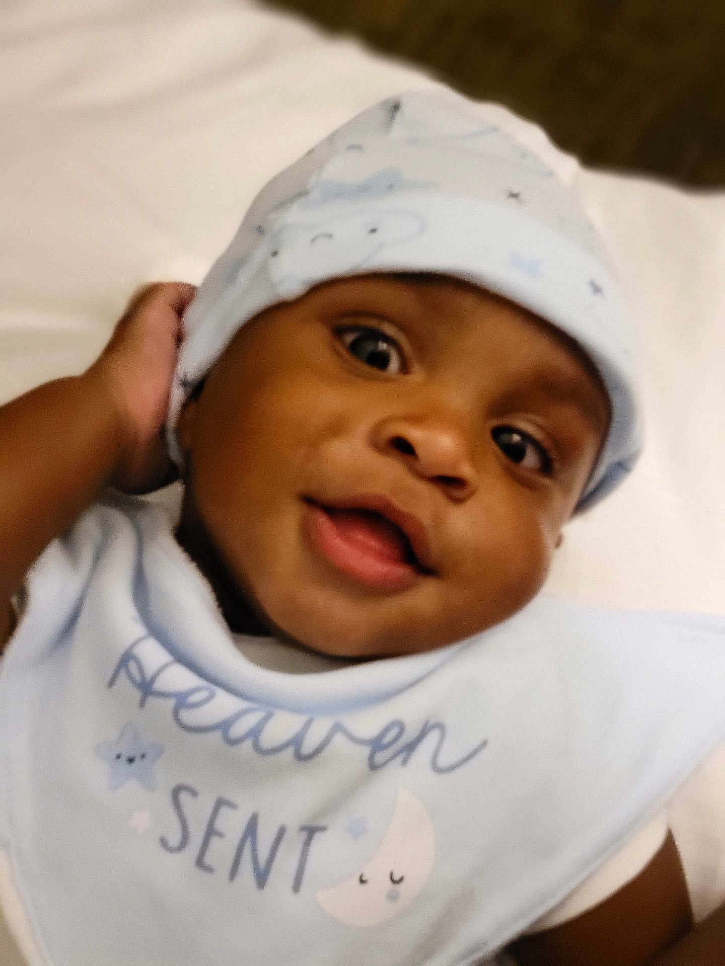 Kyree is registered to the contest to win money with this photo: baby, child, smiling, face, hat, clothing, bib, blue, cute, portrait, infant, young_child, happy, indoors, headwear, closeup, expression, person, skin, eyes