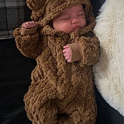 Albie joined the competition — help win amazing prizes! baby, sleeping, costume, bear_costume, hood, fluffy, brown, infant, cute, cozy, blanket, couch, soft, toddler, child, closed_eyes, relaxed, hand, foot, clothing