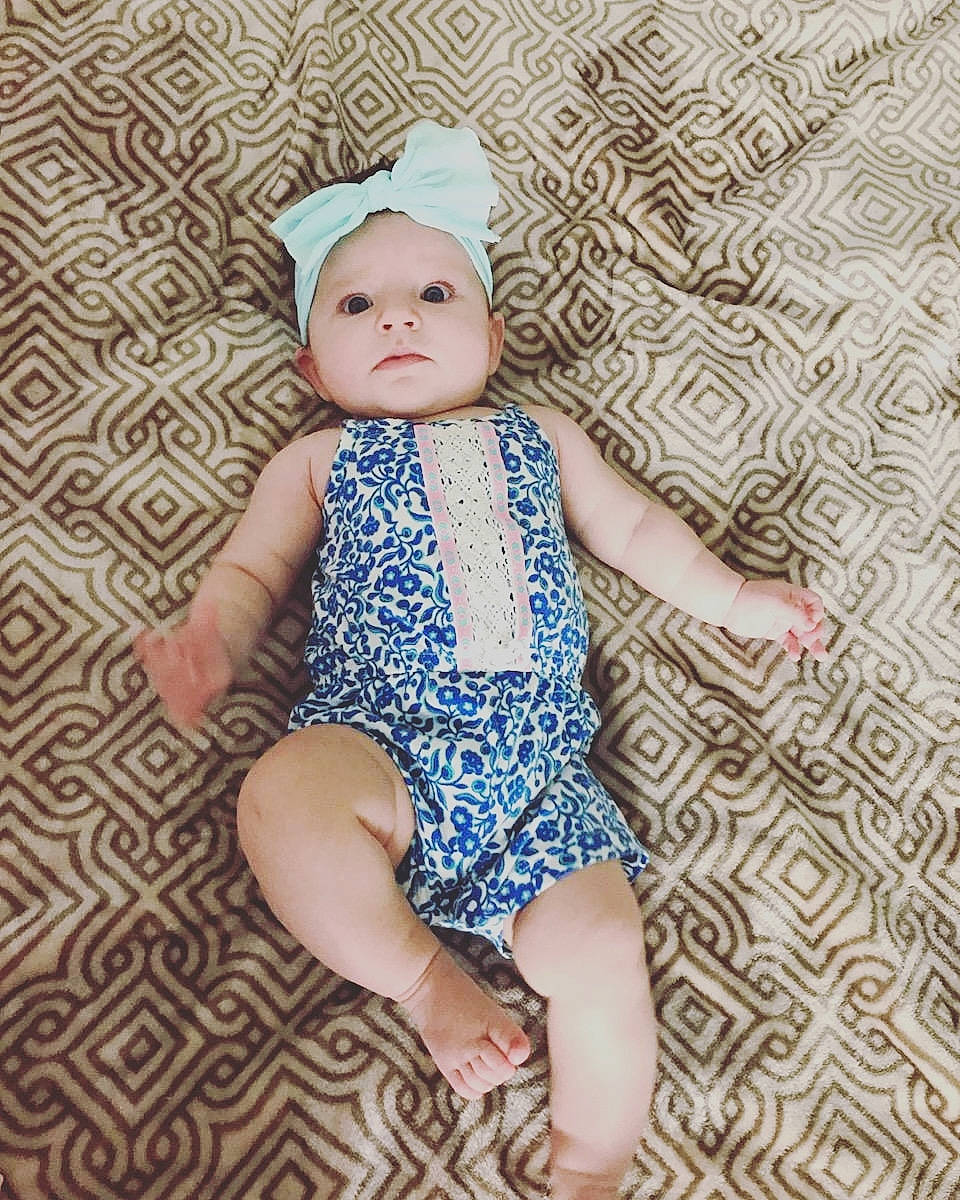 Kayce is registered to the contest to win money with this photo: baby, baby_toddler_clothing, cap, child, child_model, clothing, design, dress, headgear, pattern, person, sitting, toddler