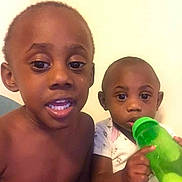 Kymani joined the competition — help win amazing prizes! child, children, baby, toddler, bottle, green_bottle, shirtless, short_hair, indoor, face, portrait, curious, looking_at_camera, sitting, young, two_people, skin, expression, person, home