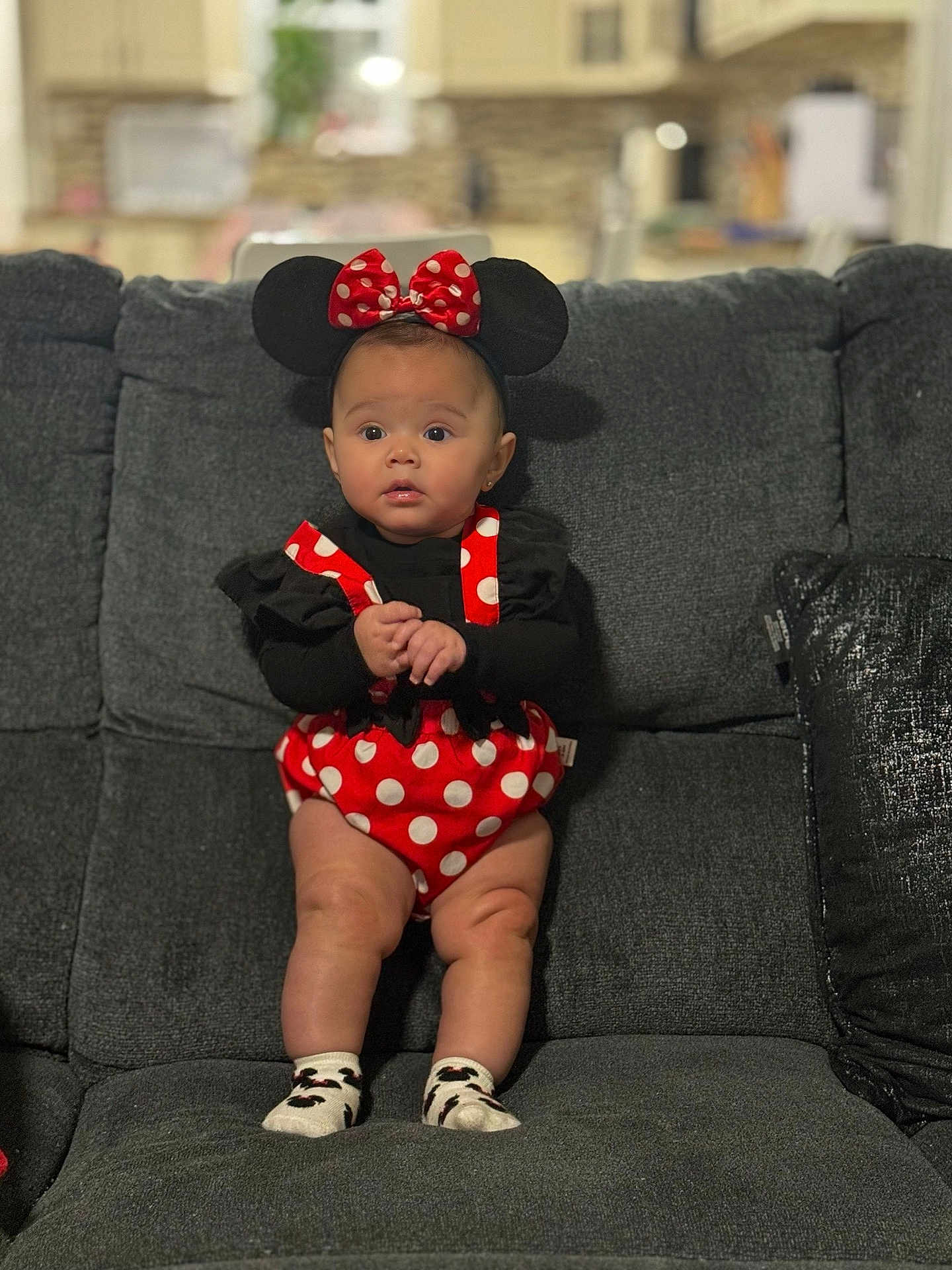 Stella is registered to the contest to win money with this photo: baby, child, infant, minnie_mouse, costume, polka_dot, red, black, socks, ears, headband, couch, sofa, indoor, portrait, cute, expression, hands, clothing, home
