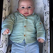 Milann participe au concours pour gagner de l'argent avec cette photo : baby, infant, crib, clothing, mint_green_shirt, blue_pants, face, eyes, hands, cute, child, smile, plush_blanket, animal_print, furniture, indoor, portrait, lying_down, cozy, young_child