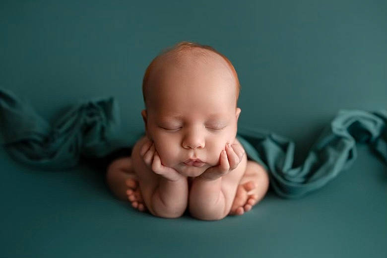 Blaine is registered to the contest to win money with this photo: baby, baby_products, baby_toddler_clothing, barefoot, cheek, child, comfort, finger, flooring, foot, gesture, happy, linens, nail, nose, person, portrait_photography, sitting, thumb, toddler