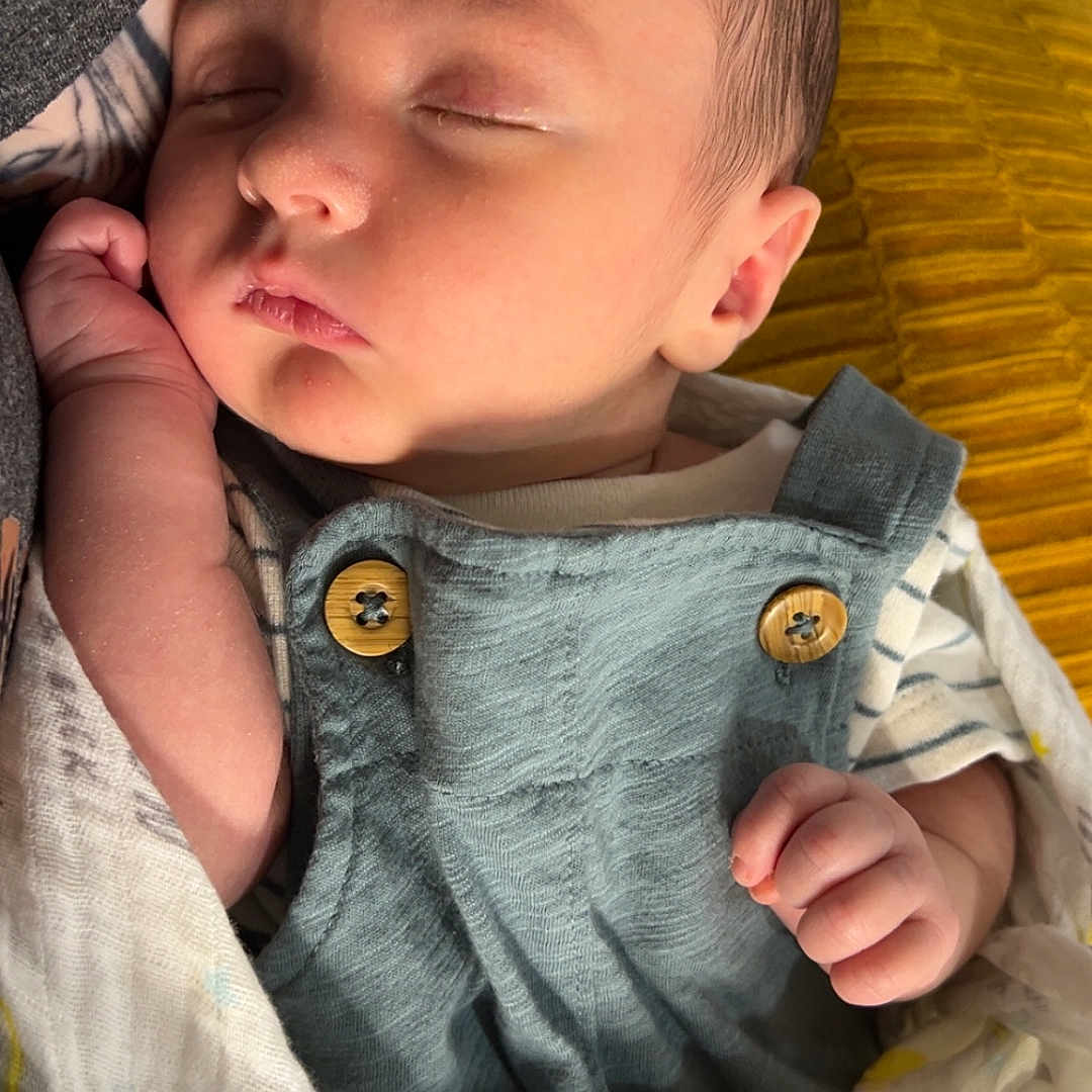 Oliver is registered to the contest to win money with this photo: baby, bed, blanket, bodypart, clothing, face, finger, furniture, hand, head, homedecor, linen, newborn, pants, person, photography, portrait, quilt, sleeping, towel