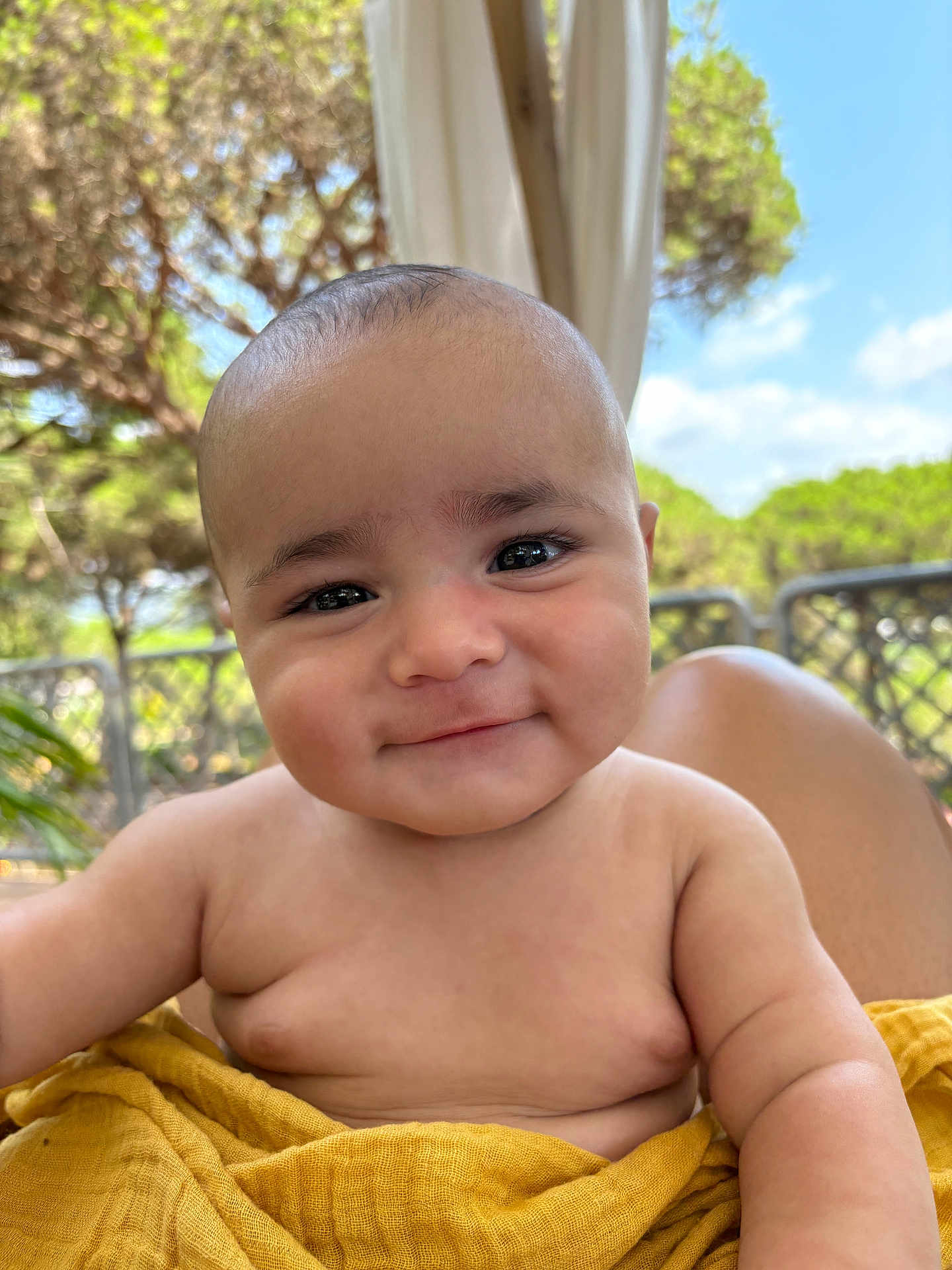 Gabriel Amore participe au concours pour gagner de l'argent avec cette photo : baby, smiling, child, outdoor, blanket, yellow_blanket, skin, face, eyes, cheeks, arm, shoulder, nature, trees, sunlight, portrait, happy, infant, cute, person