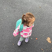 Lylou participe au concours pour gagner de l'argent avec cette photo : child, toddler, backpack, pink_jacket, heart_pattern, asphalt, pavement, sneakers, purple_shoes, hair_tie, side_profile, looking_right, outdoor, autumn_leaf, walking, cute, small_child, young_kid, casual_clothing, playful