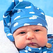 Brandon is registered to the contest to win money with this photo: baby, infant, face, blue_hat, cloud_pattern, clothing, button, blanket, soft_texture, cute, portrait, newborn, chubby_cheeks, indoors, headwear, expression, person, closeup, sleepwear, resting