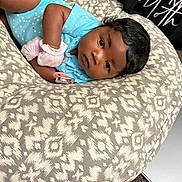Bella joined the competition — help win amazing prizes! baby, infant, blue_onesie, cushion, patterned_fabric, pacifier, baby_bottle, indoor, carpet, curly_hair, face, looking, lying_down, soft_toys, baby_mittens, child, person, resting, cute, newborn