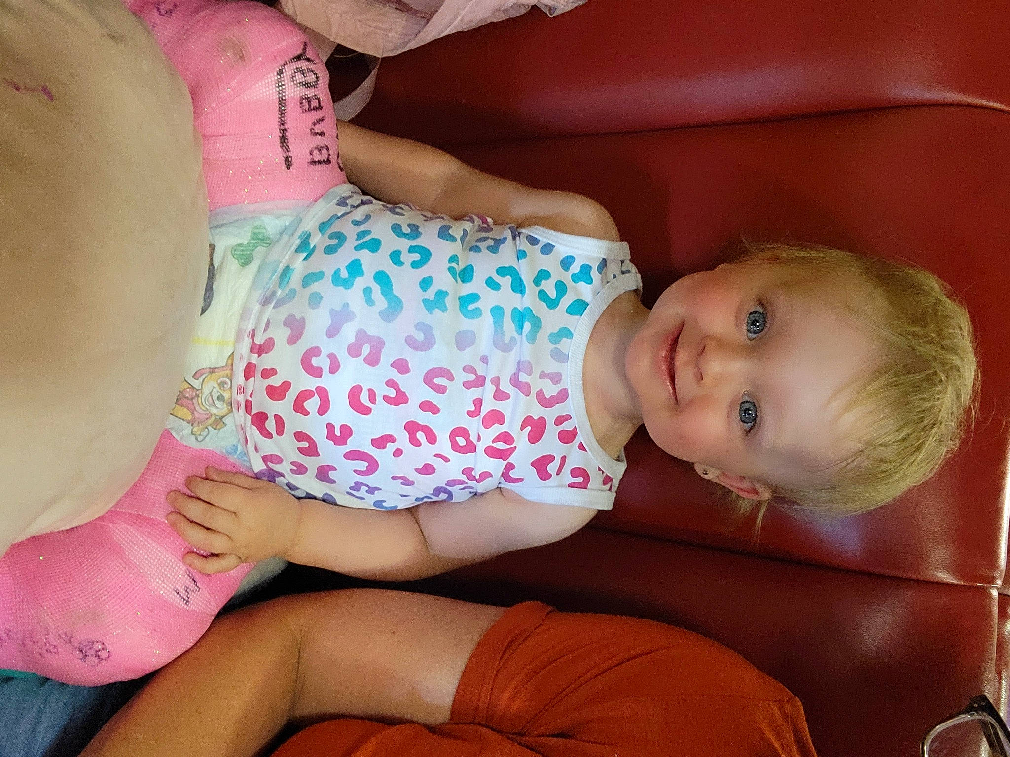 Mckenzie is registered to the contest to win money with this photo: arm, baby, baby_toddler_clothing, cheek, child, comfort, facial_expression, finger, human, human_body, human_leg, joint, joy, knee, mouth, nail, pattern, person, pink, skin