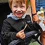 child, stroller, ice_cream, smile, outdoor, happy, person, clothing, jacket, hoodie, shorts, hand, toy, nature, tree, greenery, face, food, summer, family