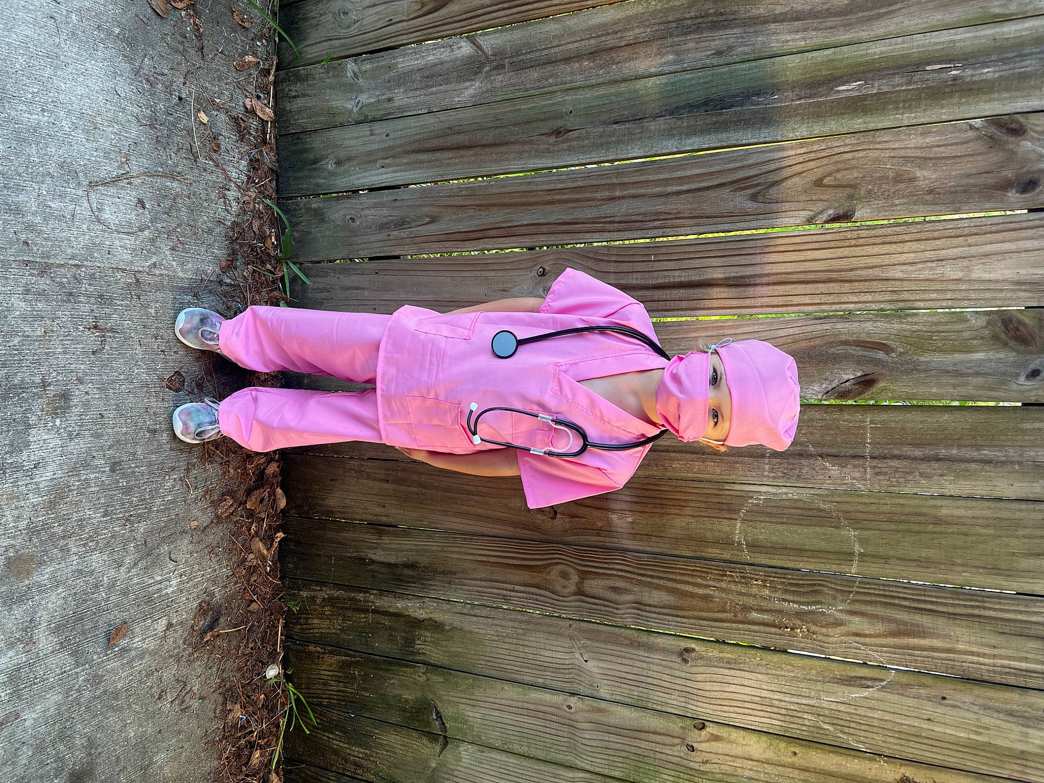 Joslyn is registered to the contest to win money with this photo: carmine, concrete, door, hardwood, hat, magenta, person, pink, plank, plant, purple, road_surface, toy, tree, wood, wood_stain